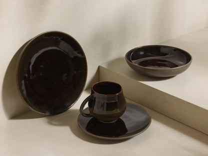 Close-up of stacked brown speckled Hearthline Dinnerware With Pasta Bowls, featuring a glossy dark brown mug.