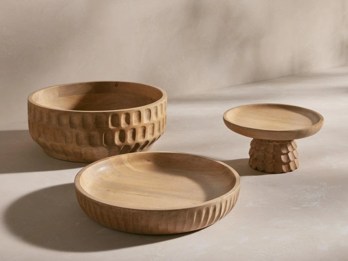 Close-up of light brown mango wood Kanga Pedestal Bowl with a smooth top and a carved scalloped-textured pedestal base.