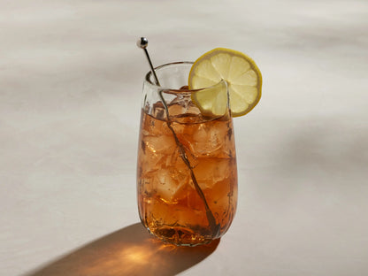 Close-up of a clear Seema Highball Glass, showing textured, hand-blown recycled glass with small bubbles.
