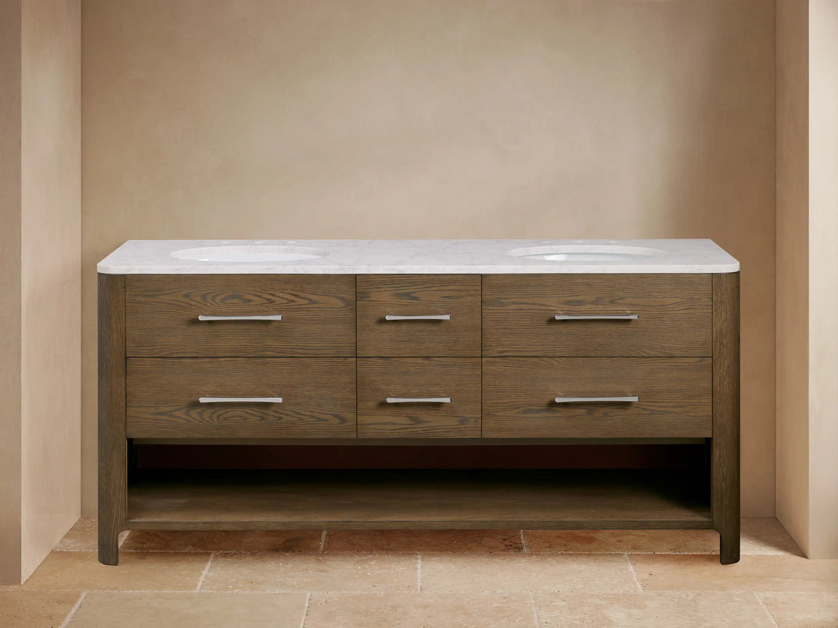 Calista Double Vanity with oak wood finish, marble top, dual sinks, metal handles, soft-closing drawers, and open shelf below.