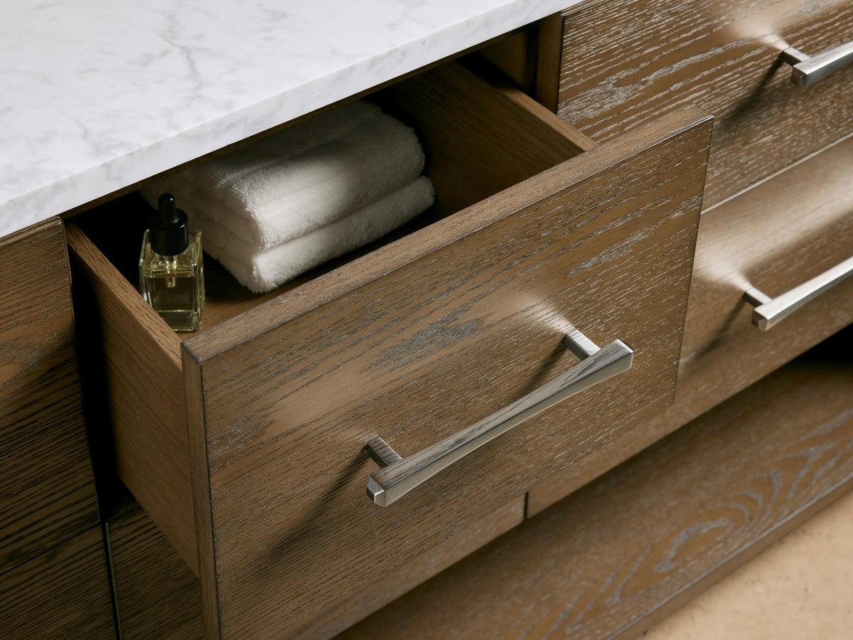 Calista Double Vanity with Carrara marble top, oval ceramic sink, silver faucet, soap and lotion dispensers on countertop.