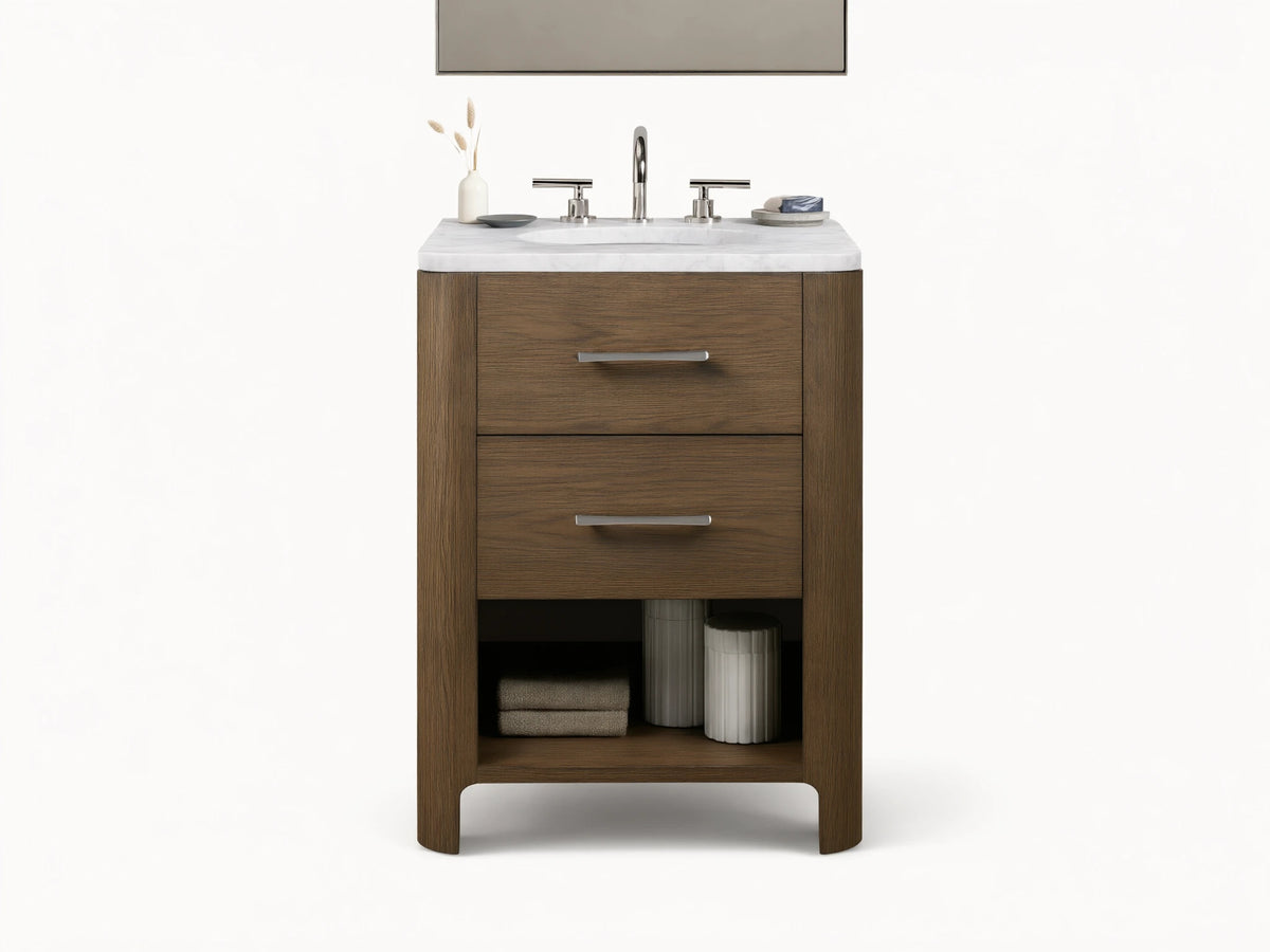 Calista Powder Vanity with oak frame, stone top, undermount sink, and two drawers, set in a neutral-toned bathroom scene.