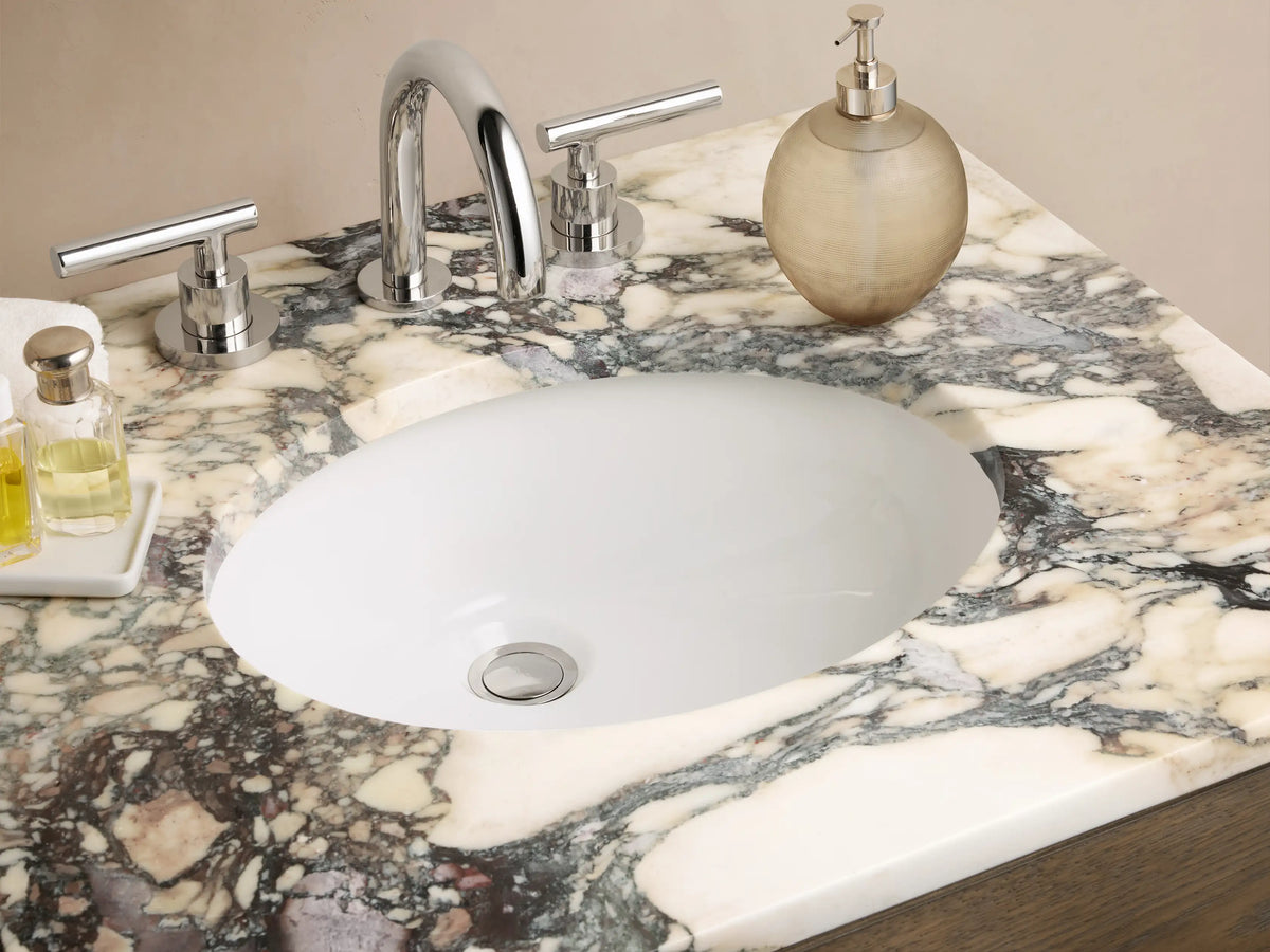 Calista Powder Vanity in dark oak wood with two drawers, polished nickel pulls, mottled marble top, and lower open shelf.