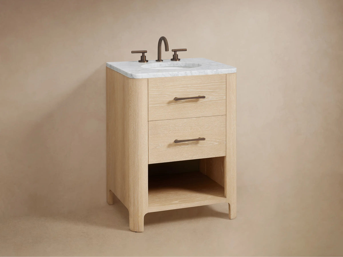 Open oak Calista Powder Vanity drawer with visible grain, white towel, wooden box, and toiletries. Features a dark bronze handle.