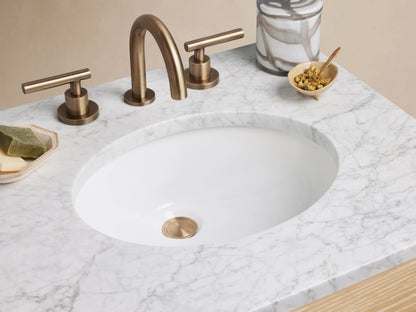 Calista Powder Vanity with oak wood finish, stone top, two drawers with brass handles, and an open shelf underneath.