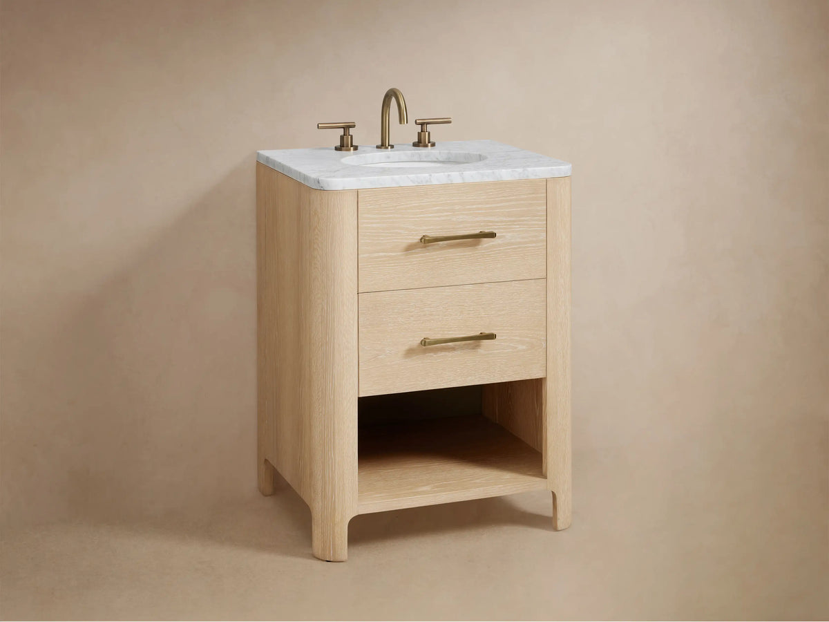 Open oak vanity drawer with soft-close glide, showing a folded towel and a wooden box inside. Antique Brass handle visible.