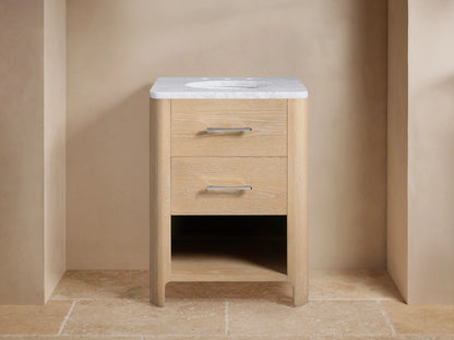 Calista Powder Vanity with light wood finish, two drawers, marble top, oval sink, silver hardware, staged against beige walls.