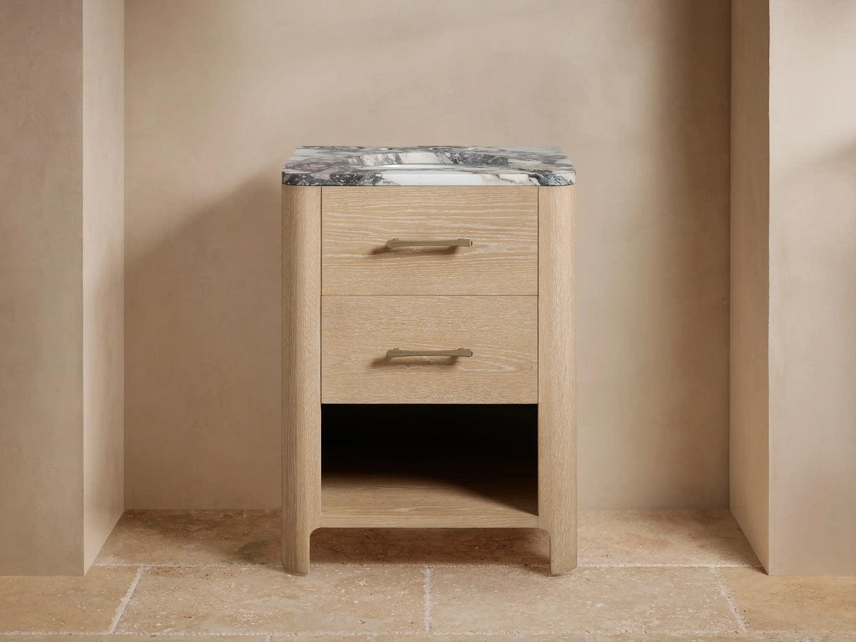 Calista Powder Vanity featuring an oak wood finish, marble top, and two drawers with brass handles, under a wall mirror.