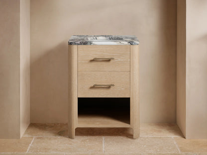 Calista Powder Vanity featuring an oak wood finish, marble top, and two drawers with brass handles, under a wall mirror.