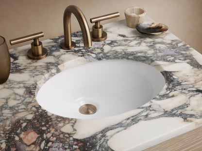 Calista Powder Vanity with an oak wood base, two drawers, and a gray-veined marble top. Set against a light beige wall.