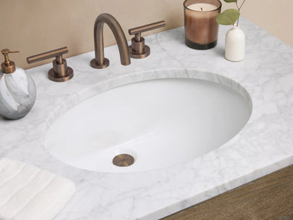 Calista Single Vanity, medium-toned oak wood with grain, white marble top, oval sink, two drawers, open shelf, on tiled floor.