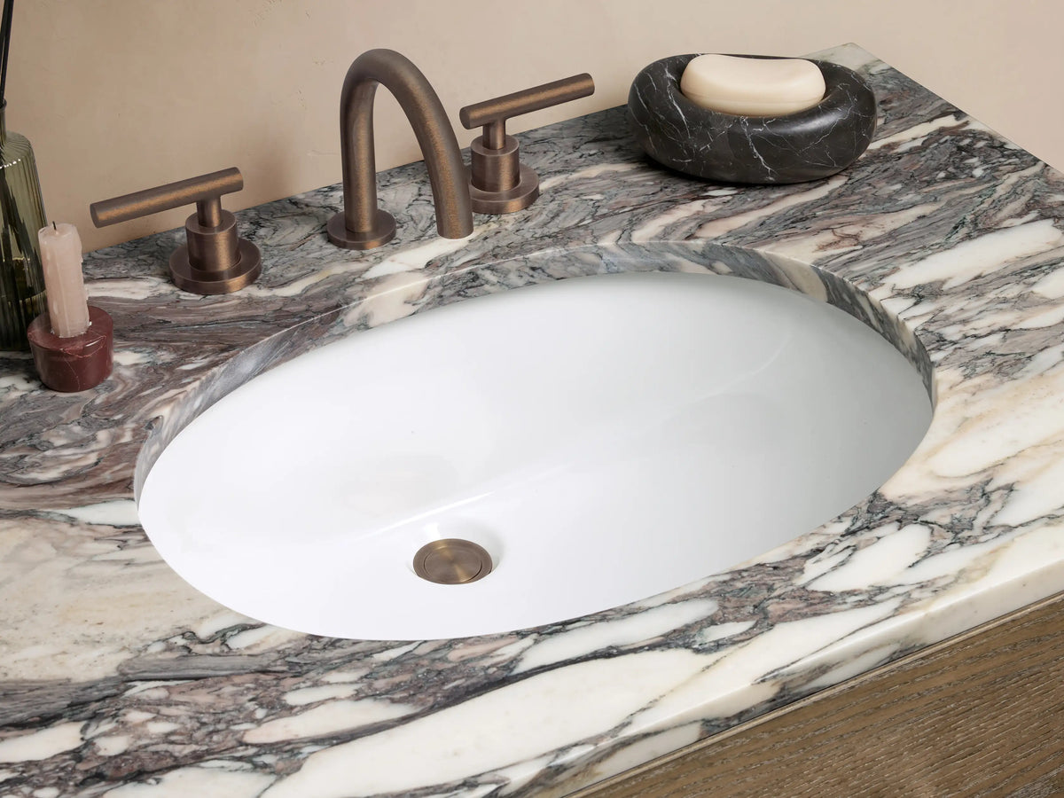 Calista Single Vanity: Medium brown oak wood vanity with two drawers, open shelf, and white marble top with dark veining.