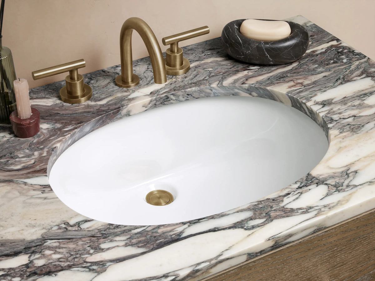 Calista Single Vanity with dark oak wood finish, two drawers, marble stone top with unique veining, and brass hardware.