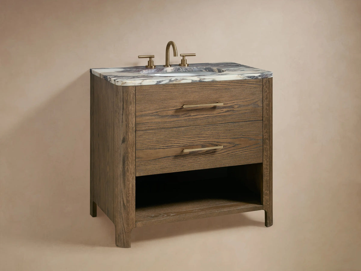 Oak wood Calista Single Vanity drawer partially open. Inside are a folded white towel and storage boxes, with brass hardware visible.