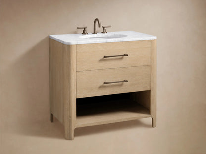 Open drawer of a light oak Calista Single Vanity, revealing toiletries inside. Features visible wood grain & dark metal handle.