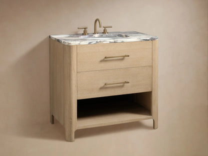 Open drawer of the Calista Single Vanity showing oak wood texture, soft-close glides, and brass handle. Contains bottles and folded towels.