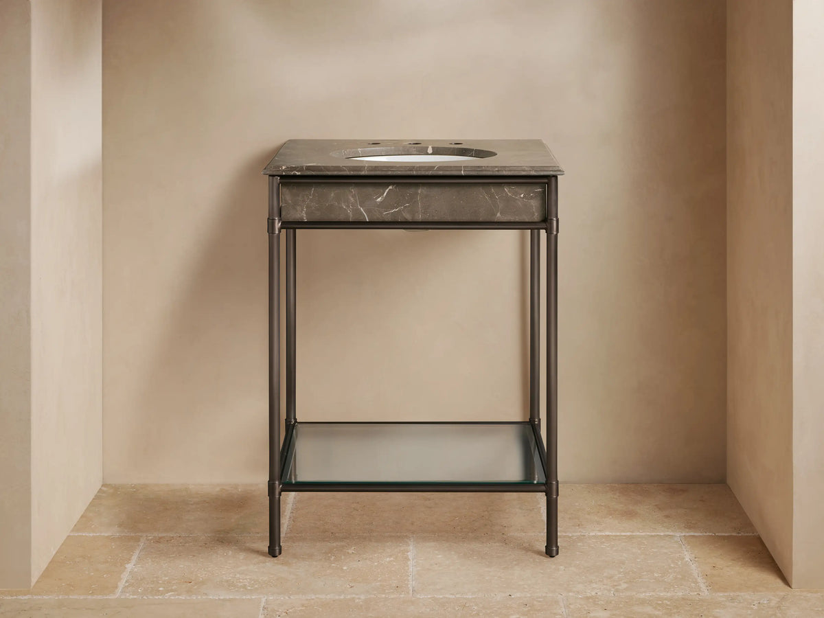 Chelsea Powder Washstand with dark bronze frame, Brown Espresso marble top, white oval sink, and bronze faucet in a powder room.