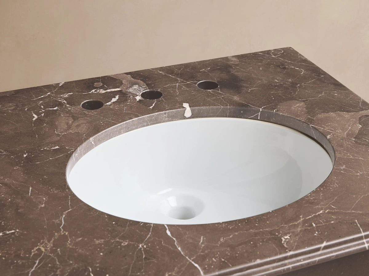 Chelsea Powder Washstand with brown marble top, white oval sink, and antique bronze widespread faucet.