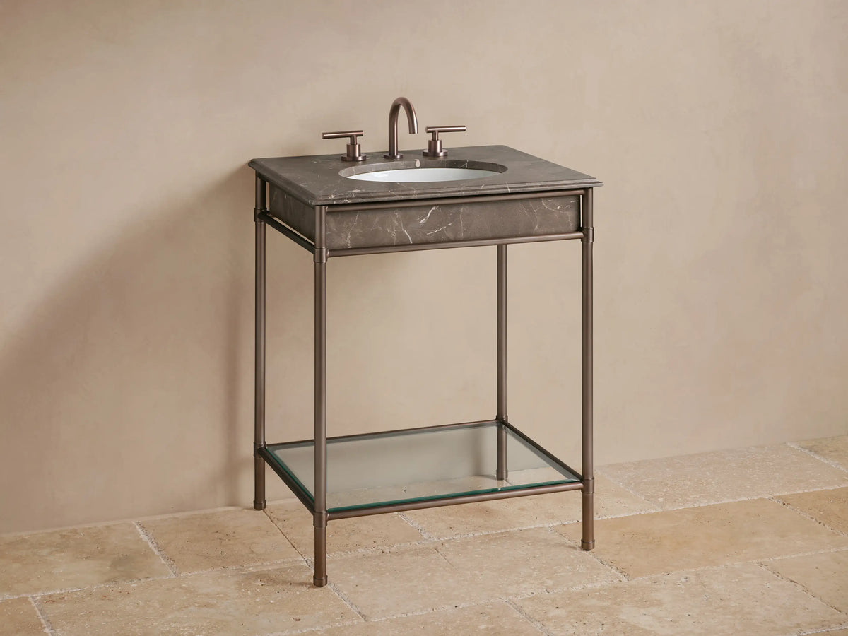 Close-up of Chelsea Powder Washstand corner; dark brown veined marble top with rounded edge on antique bronze metal frame.