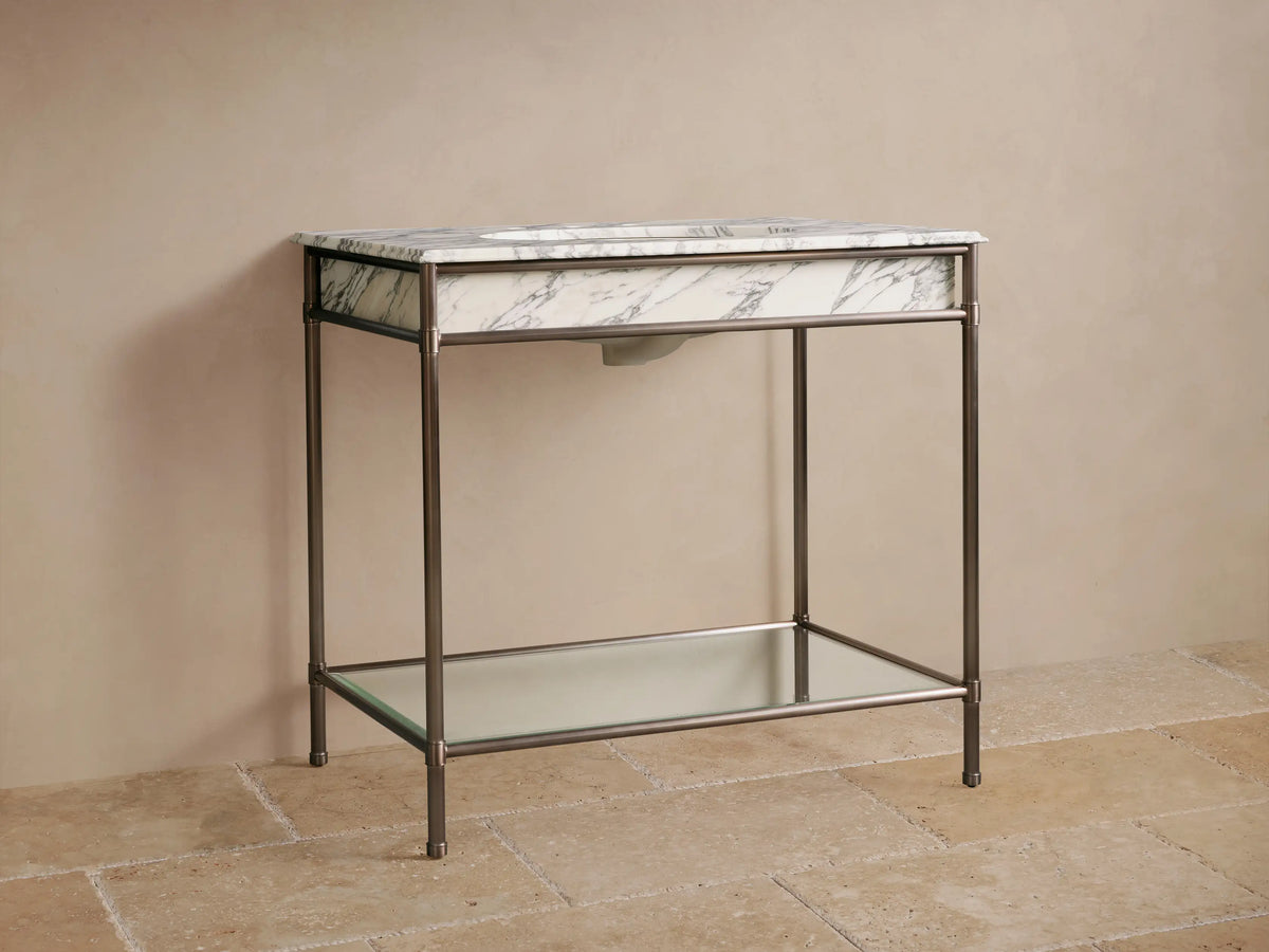 Chelsea Single Washstand: white Carrara marble top, undermount sink, dark faucet, antique bronze frame, glass shelf.