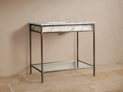 Chelsea Single Washstand: white Carrara marble top, undermount sink, dark faucet, antique bronze frame, glass shelf.