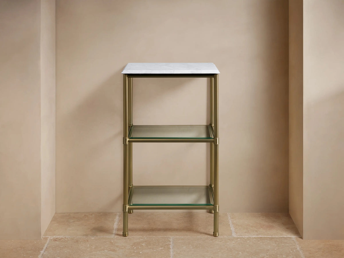 Chelsea Short Etagere with a polished nickel frame and glass shelves, holding folded beige towels.