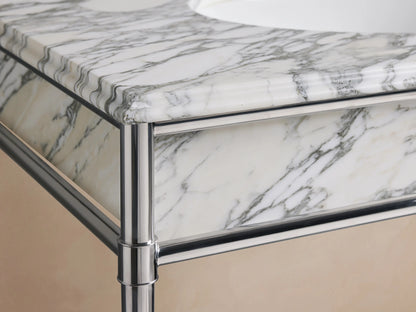 Chelsea Single Washstand close-up. White Carrara marble countertop with grey veining, oval white ceramic undermount sink, 3 faucet holes.