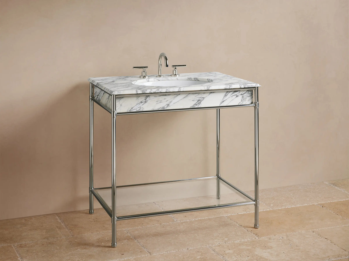 Chelsea Single Washstand: lower glass shelf on polished nickel frame, holding a beige candle, textured vase, and folded towels.
