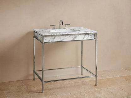 Chelsea Single Washstand: lower glass shelf on polished nickel frame, holding a beige candle, textured vase, and folded towels.