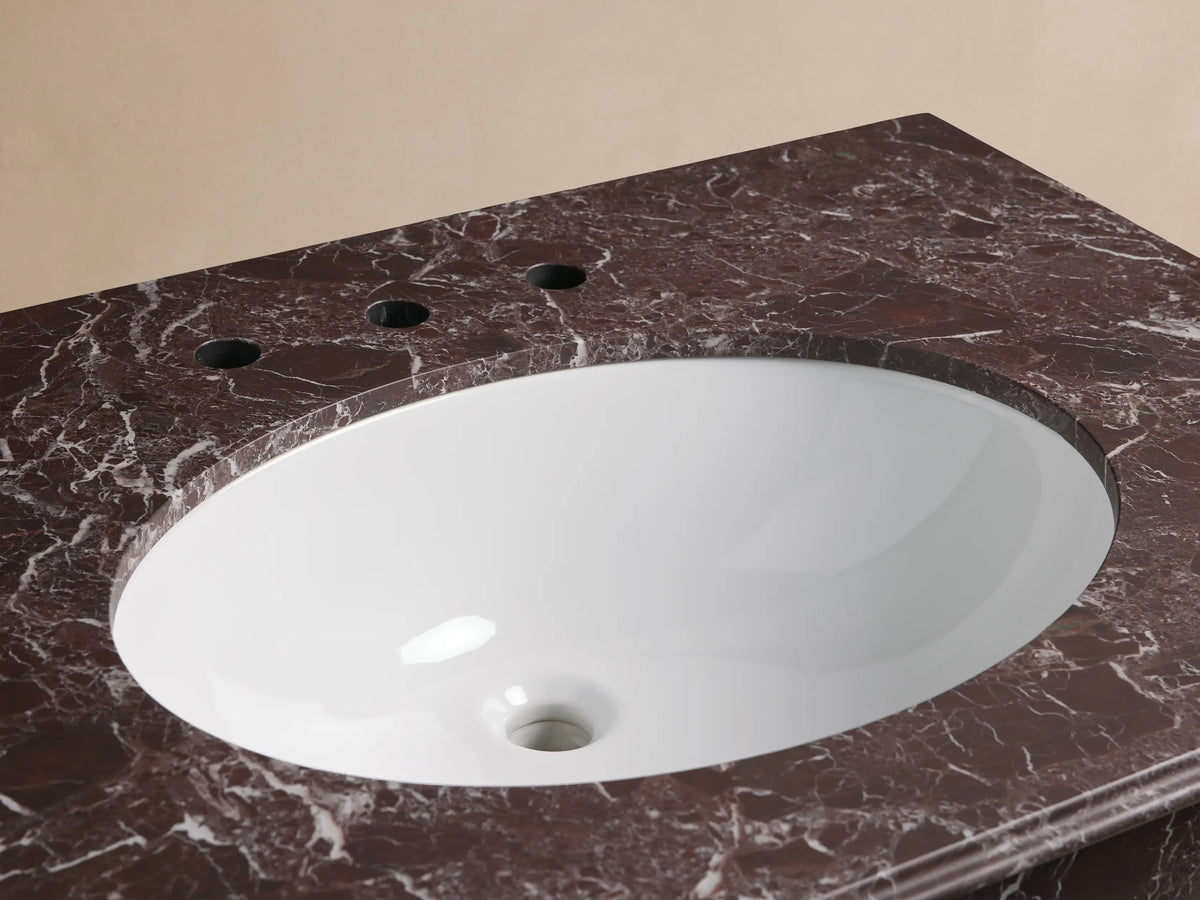 Chelsea Single Washstand: White oval undermount sink in a dark red-brown marble countertop with white veining, bronze widespread faucet.