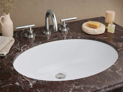 Chelsea Single Washstand. Polished chrome frame with a dark red Levanto marble top, white oval sink, & clear glass shelf.