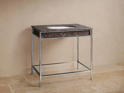 Chelsea Single Washstand with polished nickel frame, dark red marble top, white oval sink & chrome faucet against beige wall.