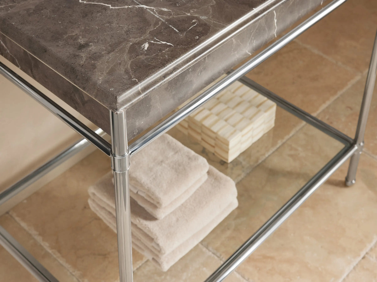 Chelsea Single Washstand: Dark veined marble countertop with white oval undermount sink, polished chrome widespread faucet.