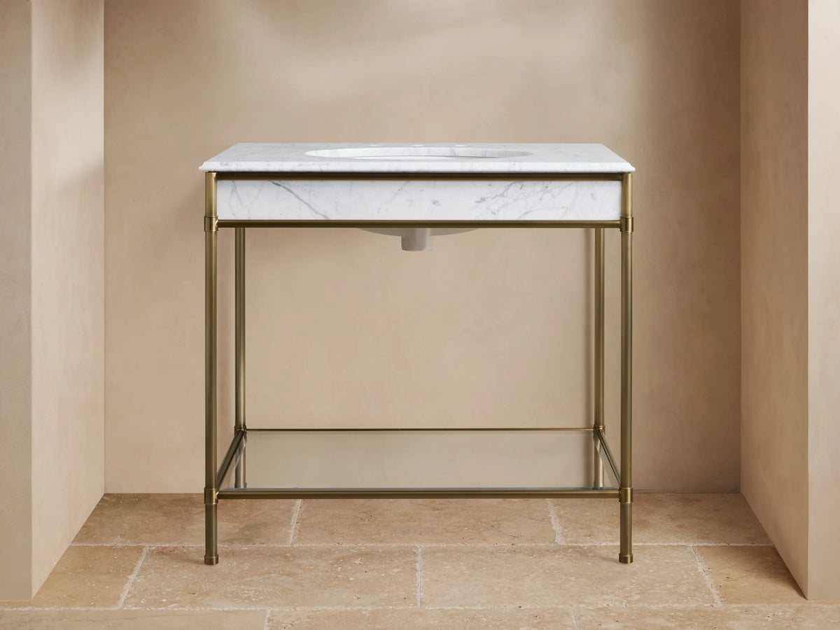Chelsea Single Washstand: white veined marble top with undermount sink, antique brass frame, and glass shelf.