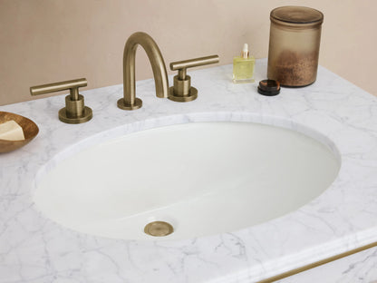 Chelsea Single Washstand: white marble top with oval sink, antique brass frame, clear glass shelf. Front view on tiled floor.