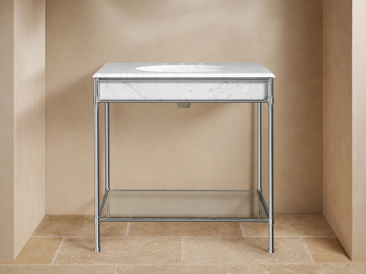 Chelsea Single Washstand with polished nickel frame, white marble top, oval ceramic sink. Lower glass shelf holds white towels & toiletries.