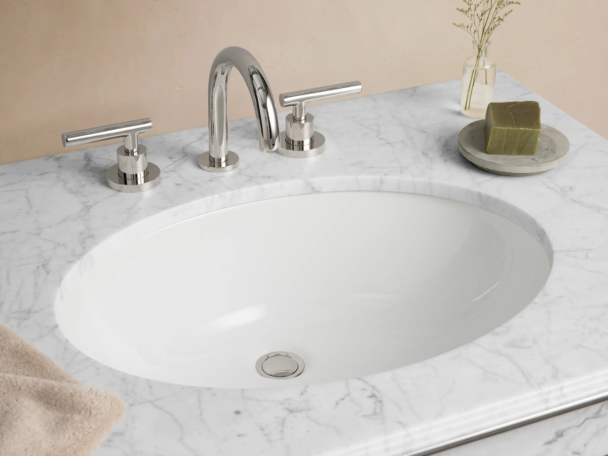 Chelsea Single Washstand, front view. White marble top with oval sink, polished nickel frame & glass shelf.