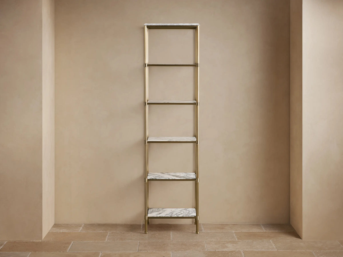 Chelsea Tall Etagere close-up. Honed white marble top with gray veining and antique brass-finished metal frame.