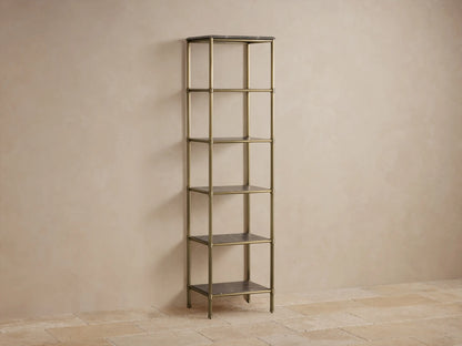 Tall five-shelf Chelsea Etagere with an antique brass finish and marble shelves, holds decor items against a beige wall.