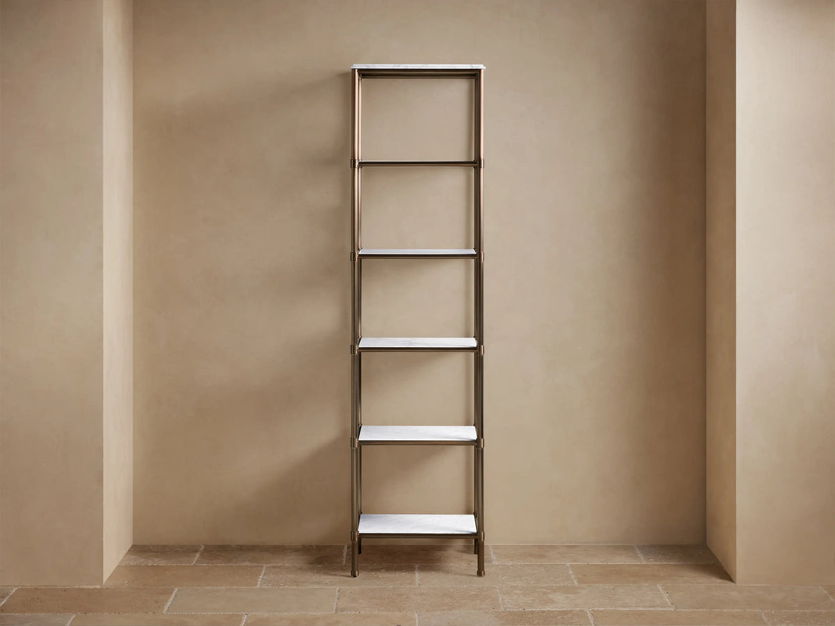 Chelsea Tall Etagere: Antique brass frame, 5 white marble shelves, styled with light towels, black and white decor on a tan wall.