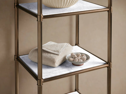 Chelsea Tall Etagere: an antique brass-finish frame with five white marble shelves, standing against a beige wall.