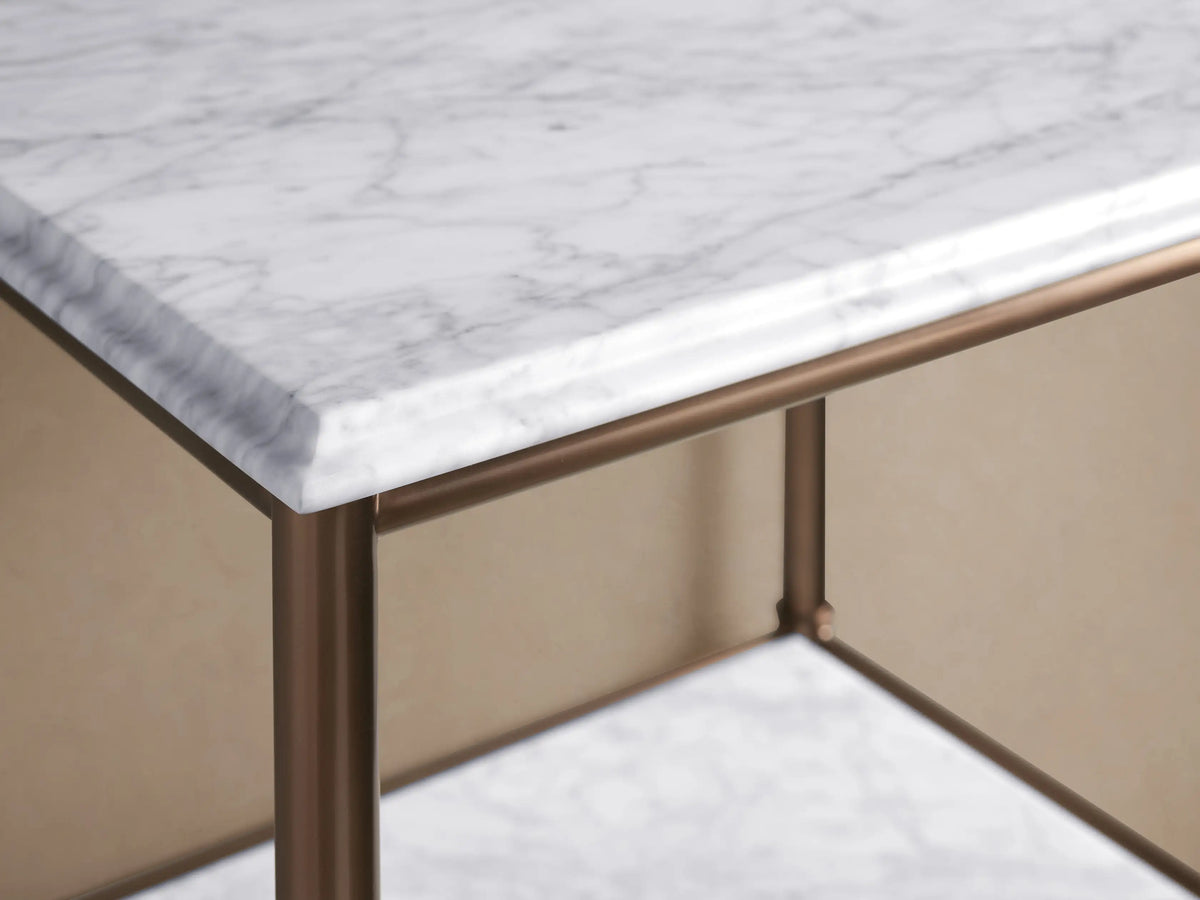 Close-up of Chelsea Tall Etagere with Antique Brass frame, white marble shelves, holding beige towels and a decorative bowl.