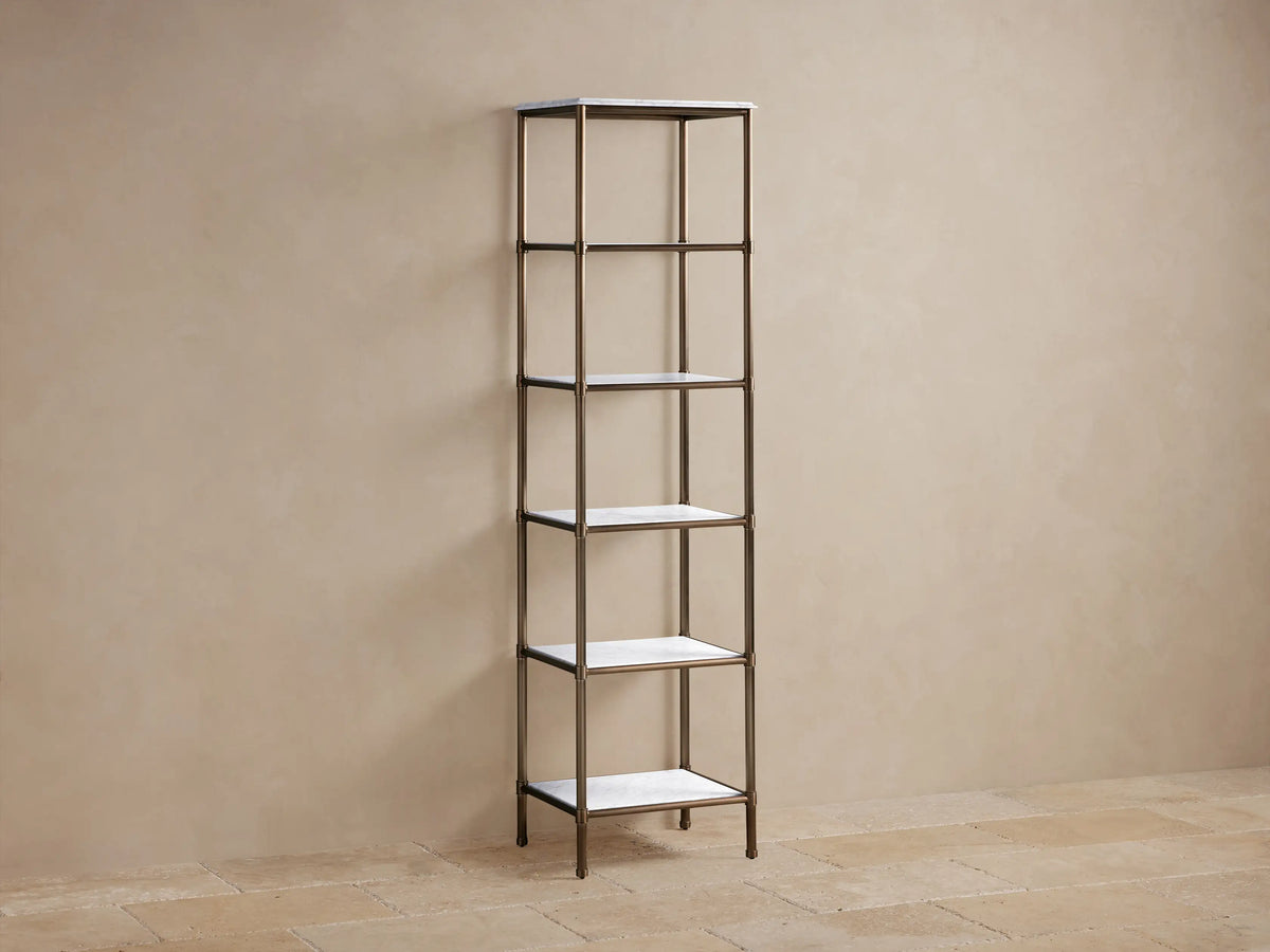 Close-up of Chelsea Tall Etagere showing honed white marble top with grey veins and warm Antique Brass frame.