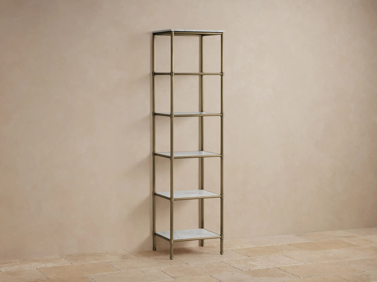 Chelsea Tall Etagere with five shelves, steel frame in antique brass finish, marble tops, styled with decorative items.