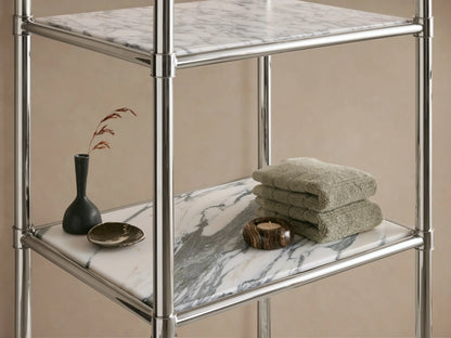 Chelsea Tall Etagere with a shiny polished nickel frame and 5 white Carrara marble shelves, against a beige wall.