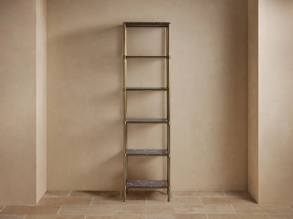 Chelsea Tall Etagere: antique brass frame, dark stone shelves. Decorated with bath items against a light wall and tiled floor.