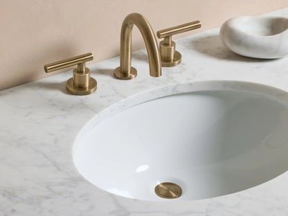 Alt text: Close-up of Crewe Smooth Faucet's round pop-up drain in antique brass finish, set against a white countertop.