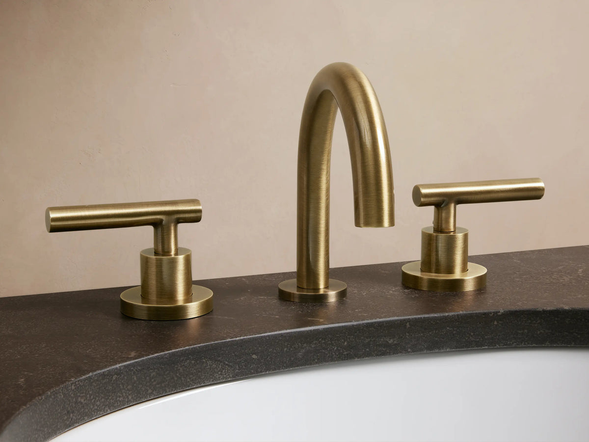 Crewe Smooth Faucet in antique brass finish, featuring an arched spout and two handles, installed on a marble countertop.