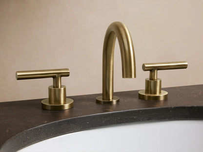 Crewe Smooth Faucet in antique brass finish, featuring an arched spout and two handles, installed on a marble countertop.