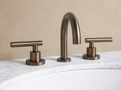 Crewe Smooth Faucet in Antique Bronze, with an arched spout and two smooth T-bar handles on a white marble counter.